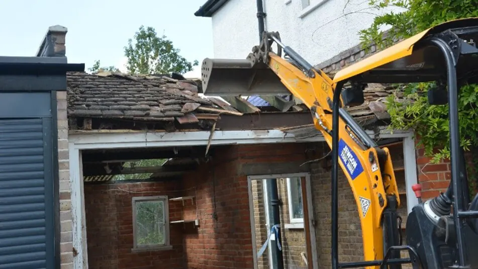 Sterkwerk breekt een oude dakconstructie af met een minigraver