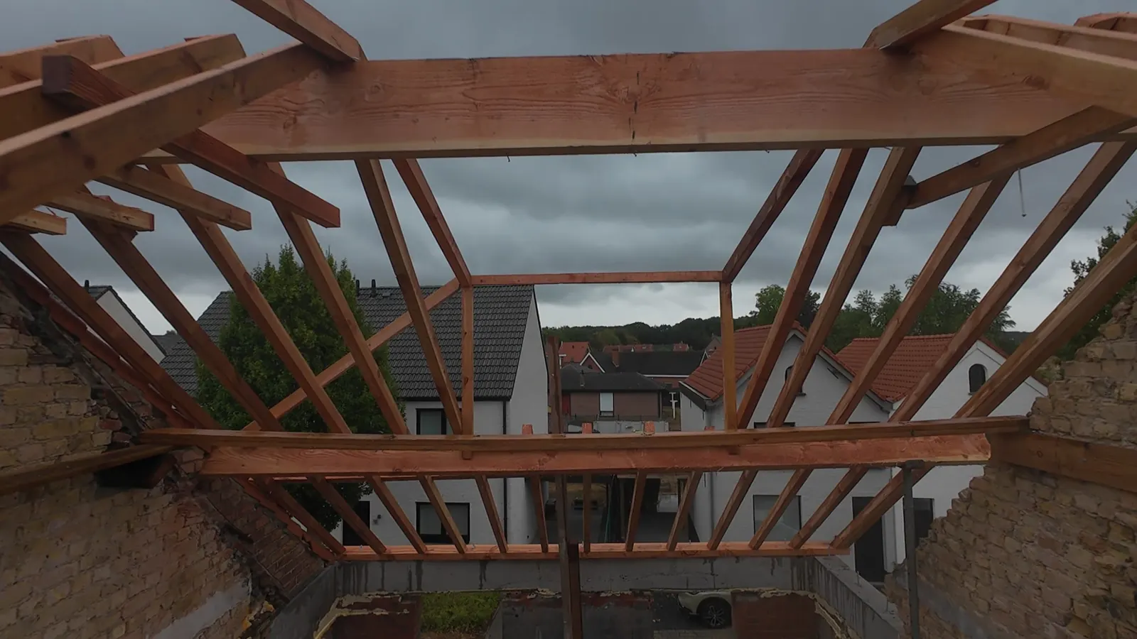 Nieuwe houten dakconstructie met spanten, van bovenaf gezien tijdens de opbouw