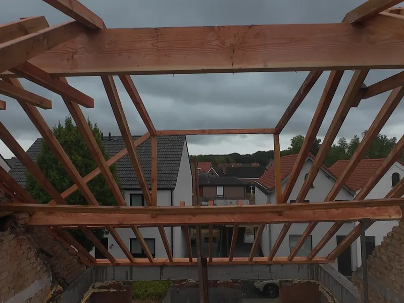 Nieuwe houten dakconstructie met spanten, van bovenaf gezien tijdens de opbouw
