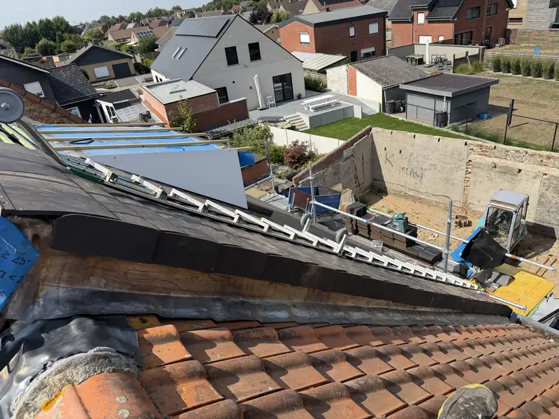 Dakrenovatie in uitvoering: de nieuwe dakbedekking sluit aan op de oude rode dakpannen