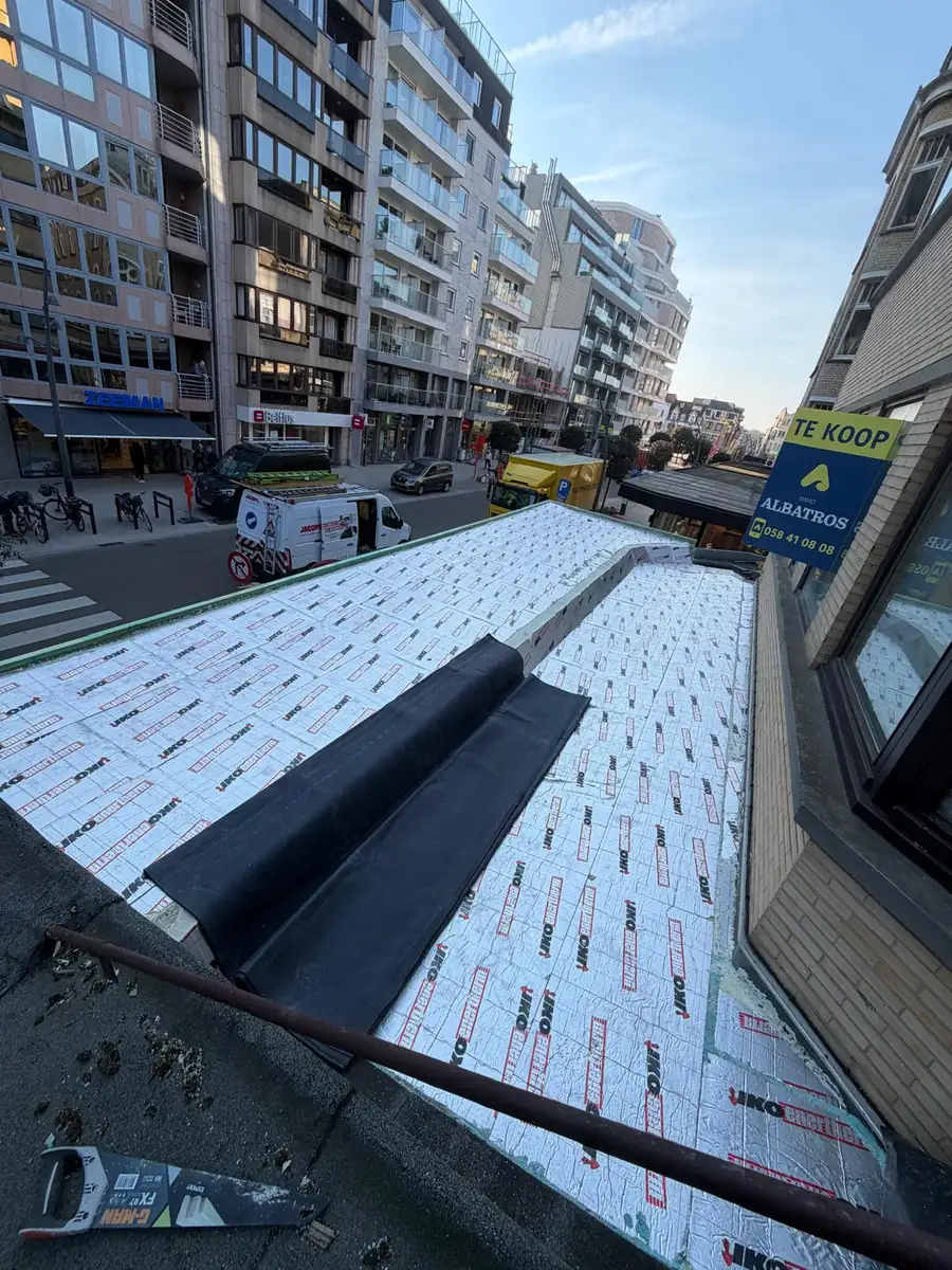 Plat dak in aanbouw met IKO Enertherm isolatieplaten op een appartementsgebouw aan de kust