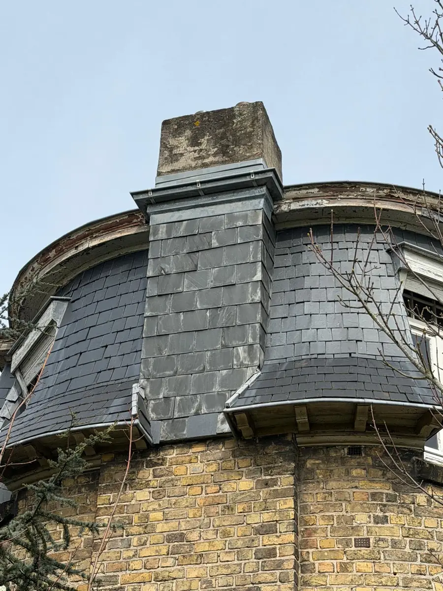 Leien dak met dakkapel en gemetselde schouw van een herenhuis voor renovatie