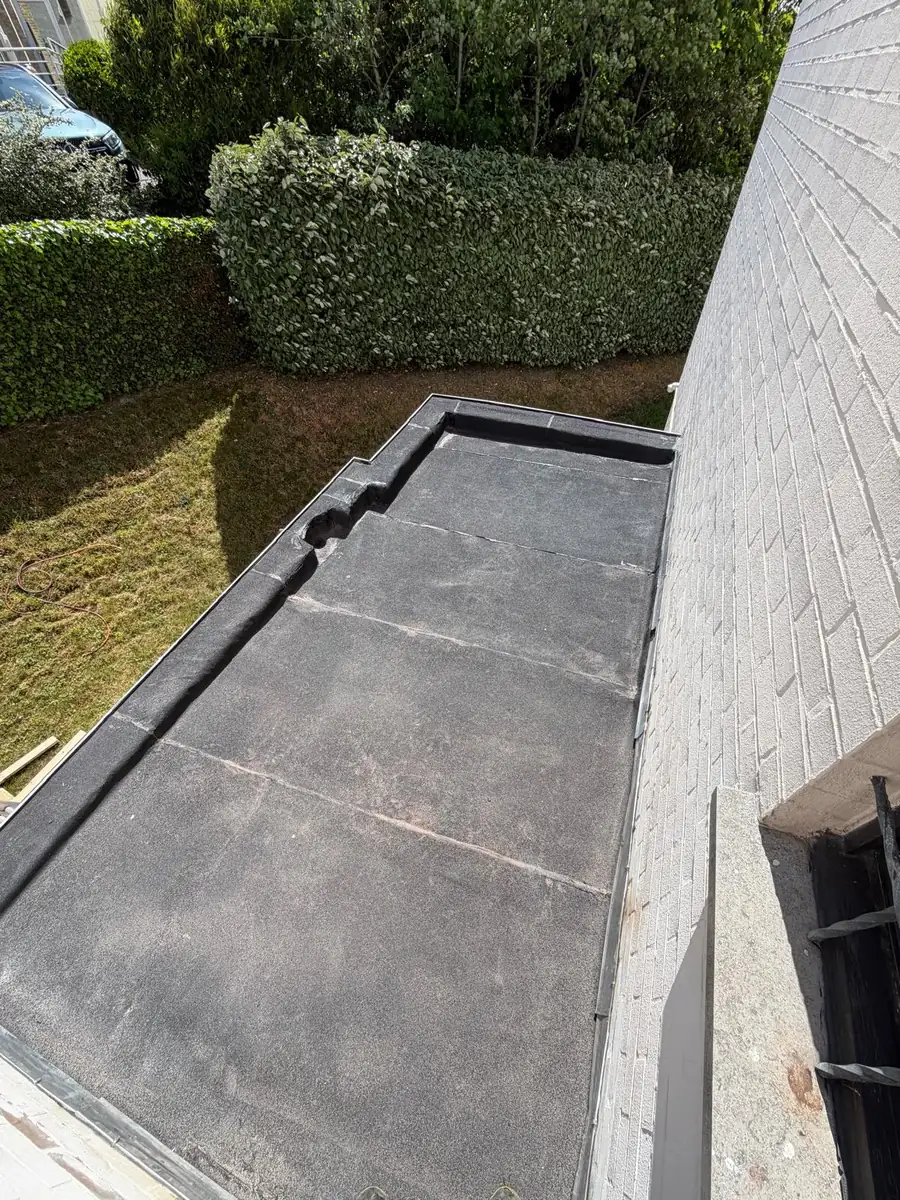 Afgewerkt plat dak in EPDM met nette dakrand, uitkijkend op de tuin