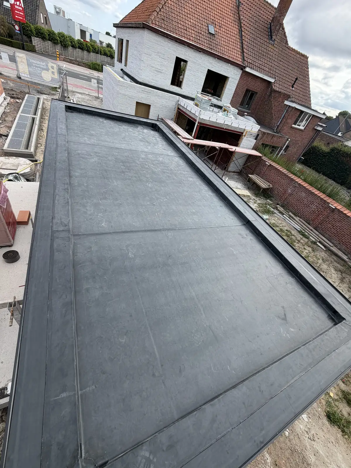 Afgewerkt plat dak in EPDM op een aanbouw, met strakke dakrand en aansluiting op de gevel