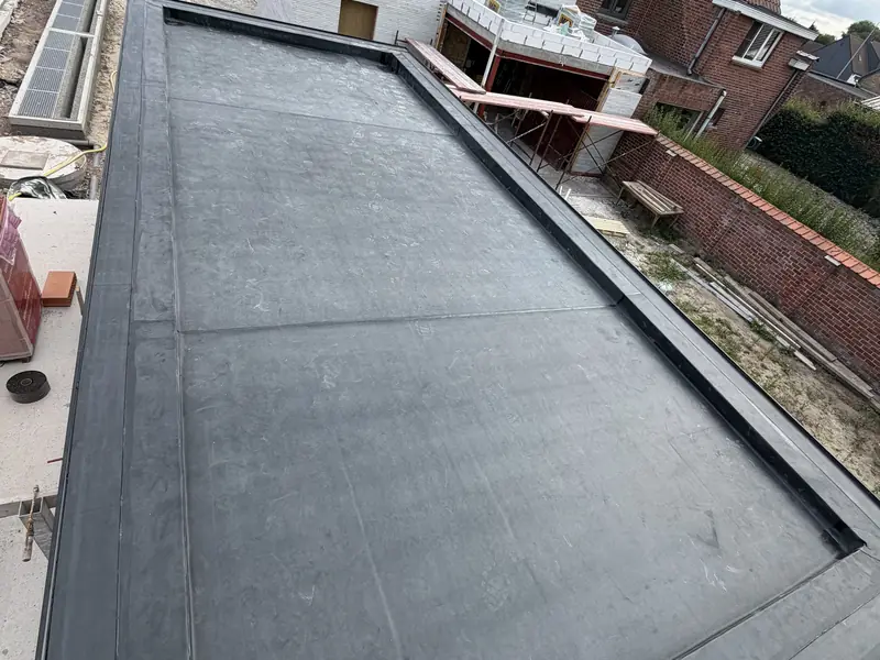 Afgewerkt plat dak in EPDM op een aanbouw, met strakke dakrand en aansluiting op de gevel