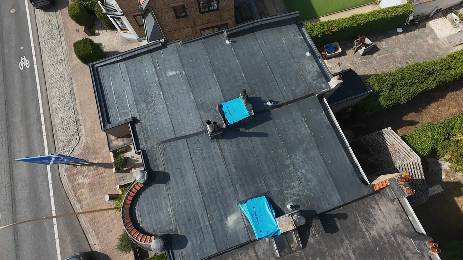 Luchtbeeld van een groot plat dak met opstaande randen en aansluitingen op de omliggende gevels