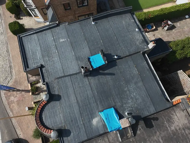 Luchtbeeld van een groot plat dak met opstaande randen en aansluitingen op de omliggende gevels
