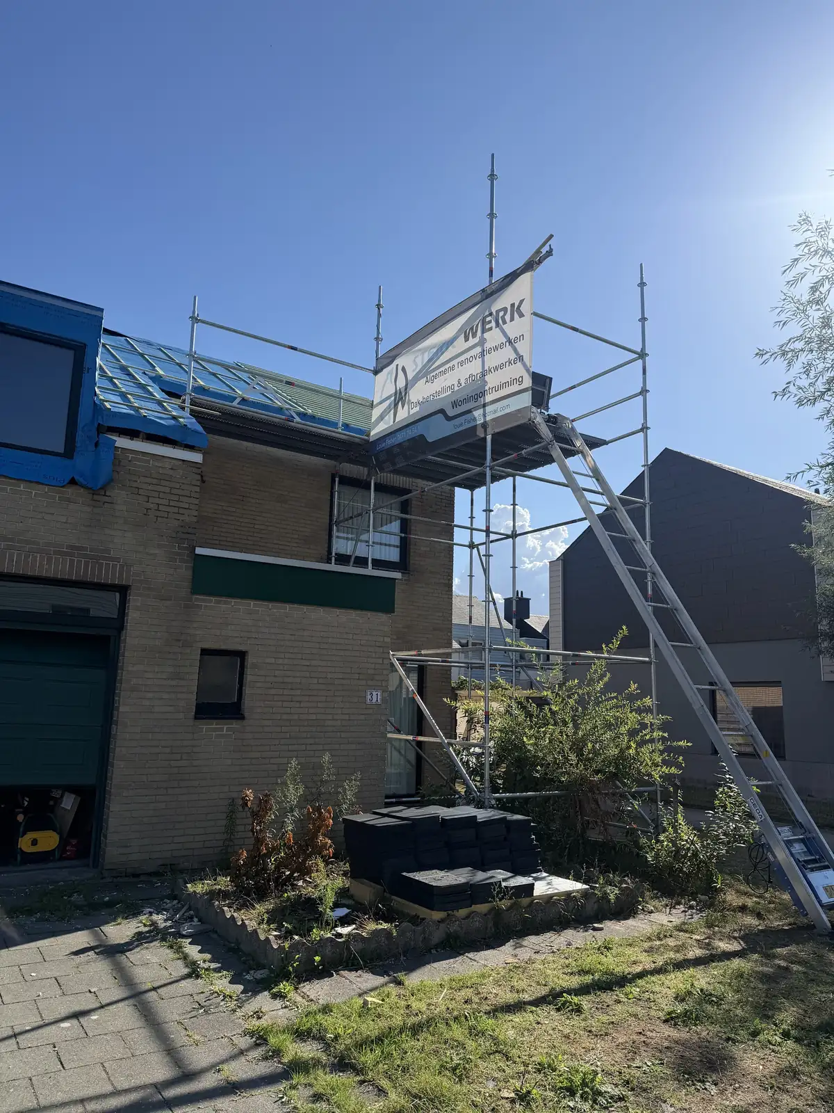 Stelling met de banner van Sterkwerk Dakwerken tegen een woning in renovatie